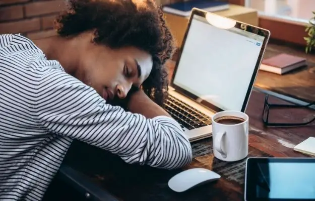 一個男人在桌子上拿著筆記本電腦和咖啡打盹| 高分辨率照片| CLIPARTO  午睡 |  休息時間如何提高你的工作表現