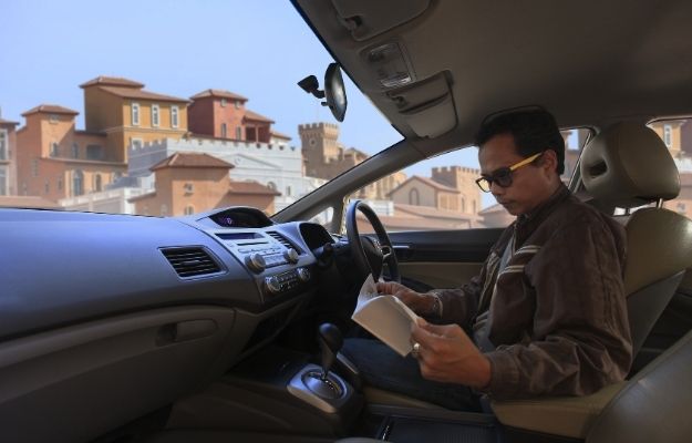 一個男人在車裡看一本手冊- ss |  在路上成為更好的司機的 6 種方法  了解你的車